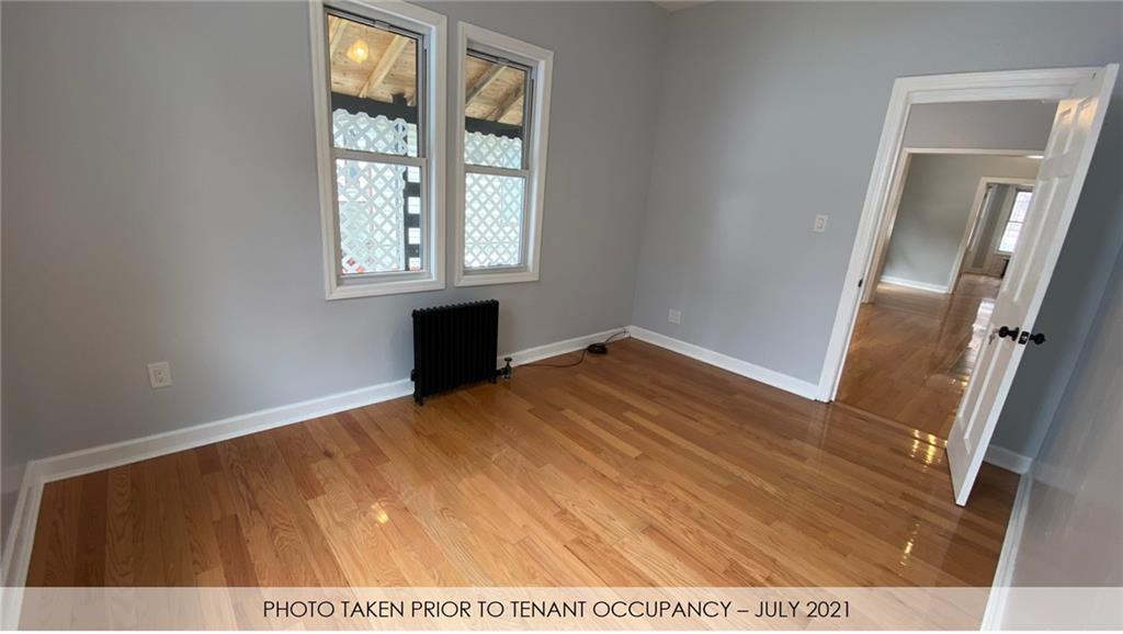 3216 Glenwood Road Brooklyn, NY 11210 - Photo 46 of 50 a view of an empty room with wooden floor and a window