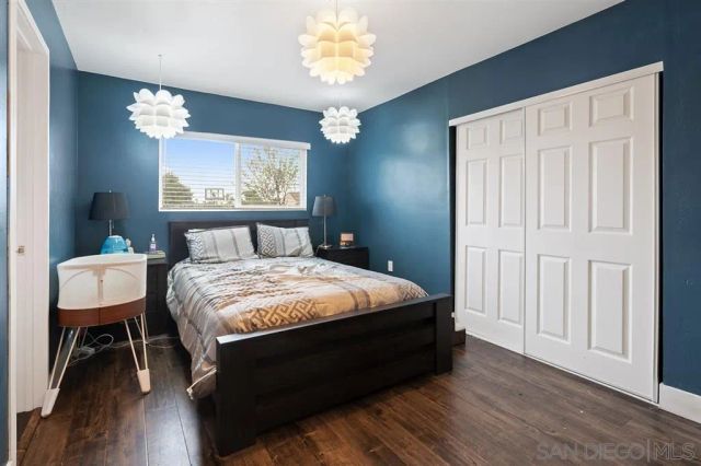a bedroom with a bed mirror on desk and a window
