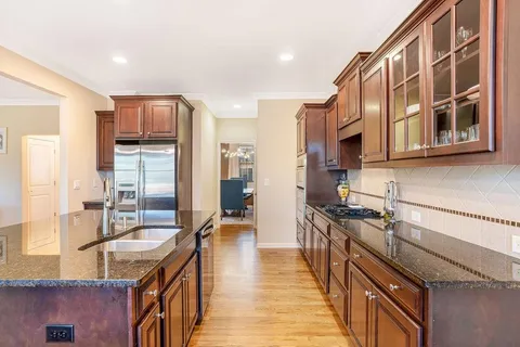 a kitchen with stainless steel appliances granite countertop a sink a stove and a refrigerator