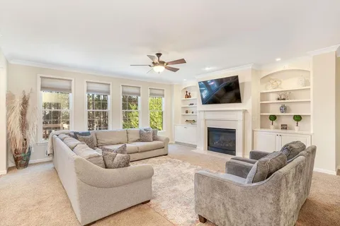 a living room with furniture a fireplace and a flat screen tv