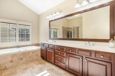 a spacious bathroom with a granite countertop tub sink and mirror