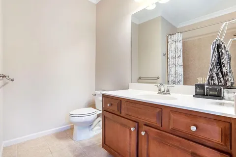 a bathroom with a granite countertop sink a toilet and a mirror