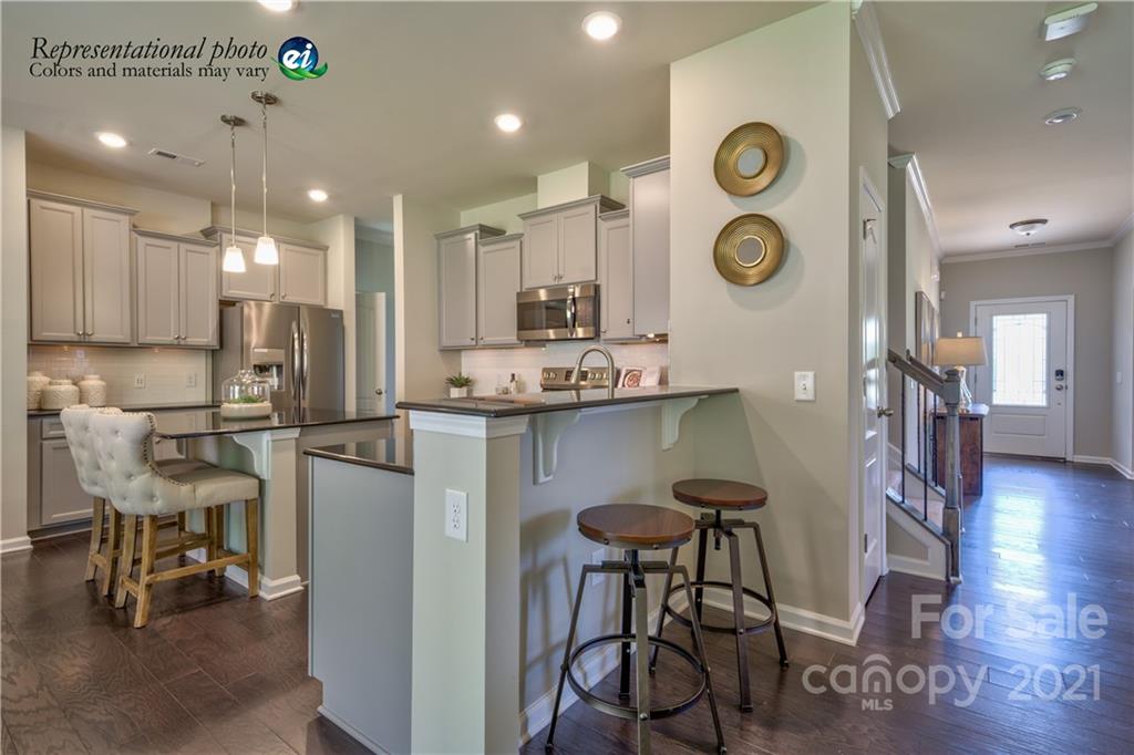 116 Tackle, Unit DRIVE 266 Troutman, NC 28166 - Photo 4 of 15 a kitchen with stainless steel appliances kitchen island granite countertop a table and chairs in it