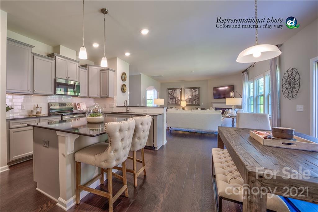 116 Tackle, Unit DRIVE 266 Troutman, NC 28166 - Photo 8 of 15 a kitchen with stainless steel appliances kitchen island granite countertop a table chairs sink and cabinets