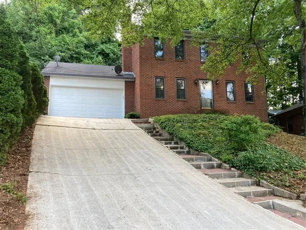 a front view of a house with yard and trees