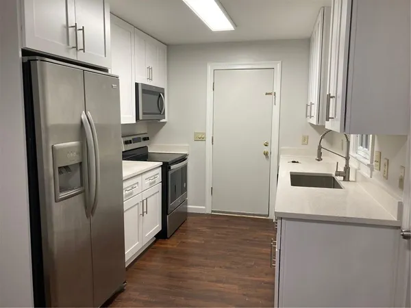 a kitchen with stainless steel appliances a refrigerator sink and microwave