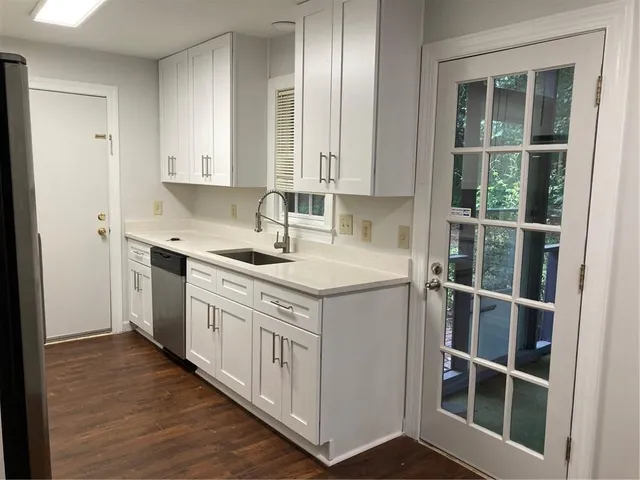 a kitchen with stainless steel appliances granite countertop a stove a sink and a refrigerator with wooden floors