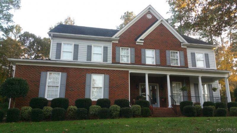 front view of a brick house with a yard