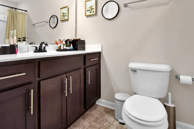a bathroom with a toilet sink vanity and mirror