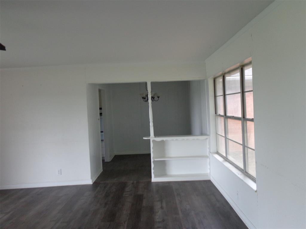 612 South Files Street Itasca, TX 76055 - Photo 18 of 30 Empty room featuring dark wood finished floors and crown molding
