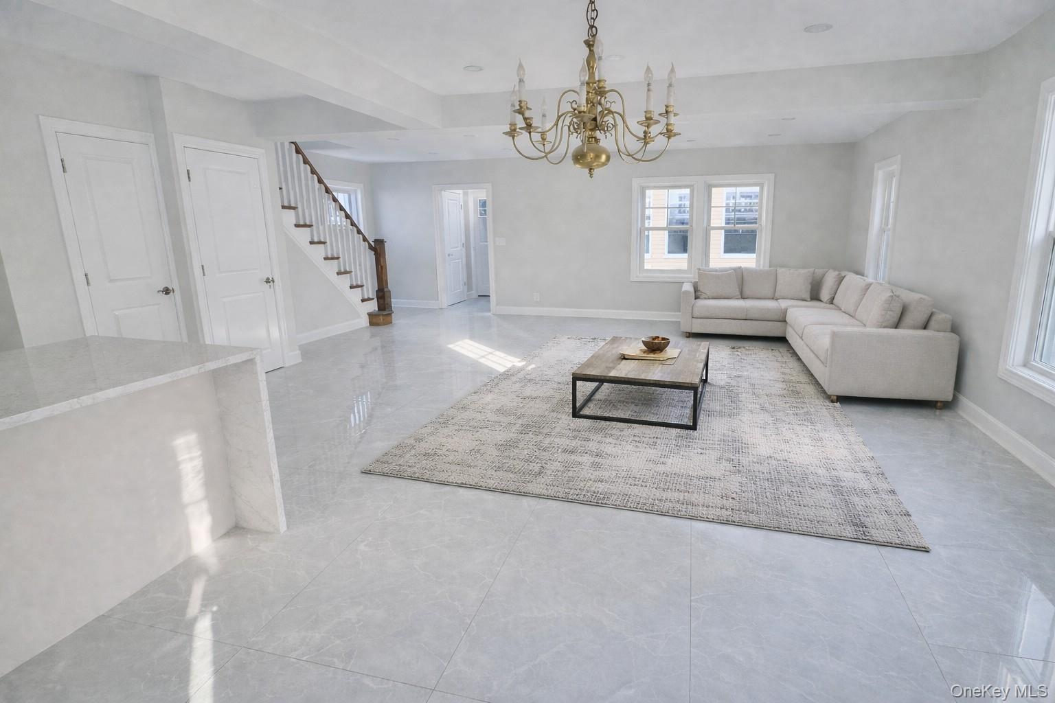 Living room Staged featuring stairway and a chandelier