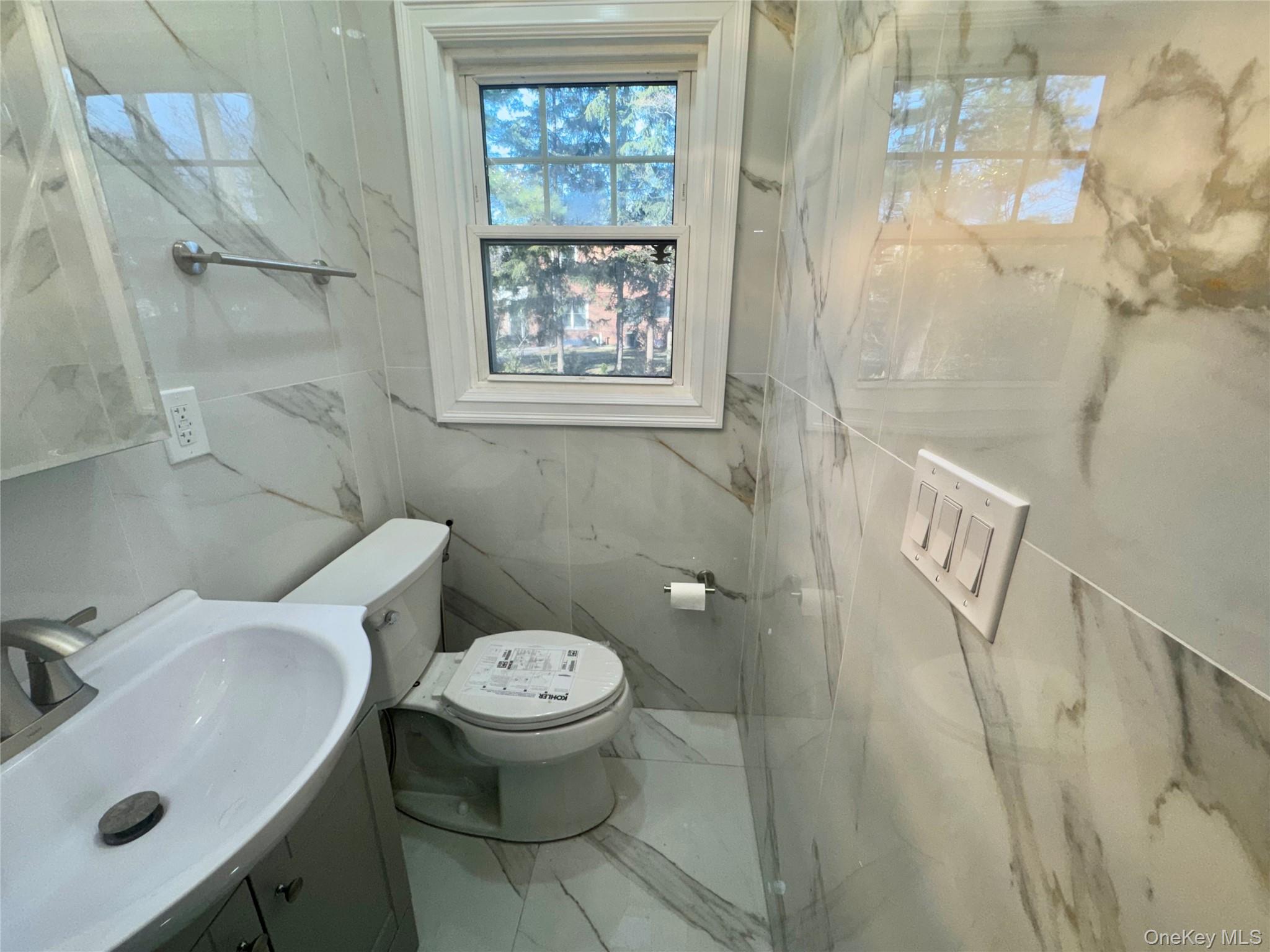 32 A Berkshire Road Great Neck, NY 11023 - Photo 16 of 38 Half bath in first floor with vanity, marble tiled flooring, and a marble finish shower
