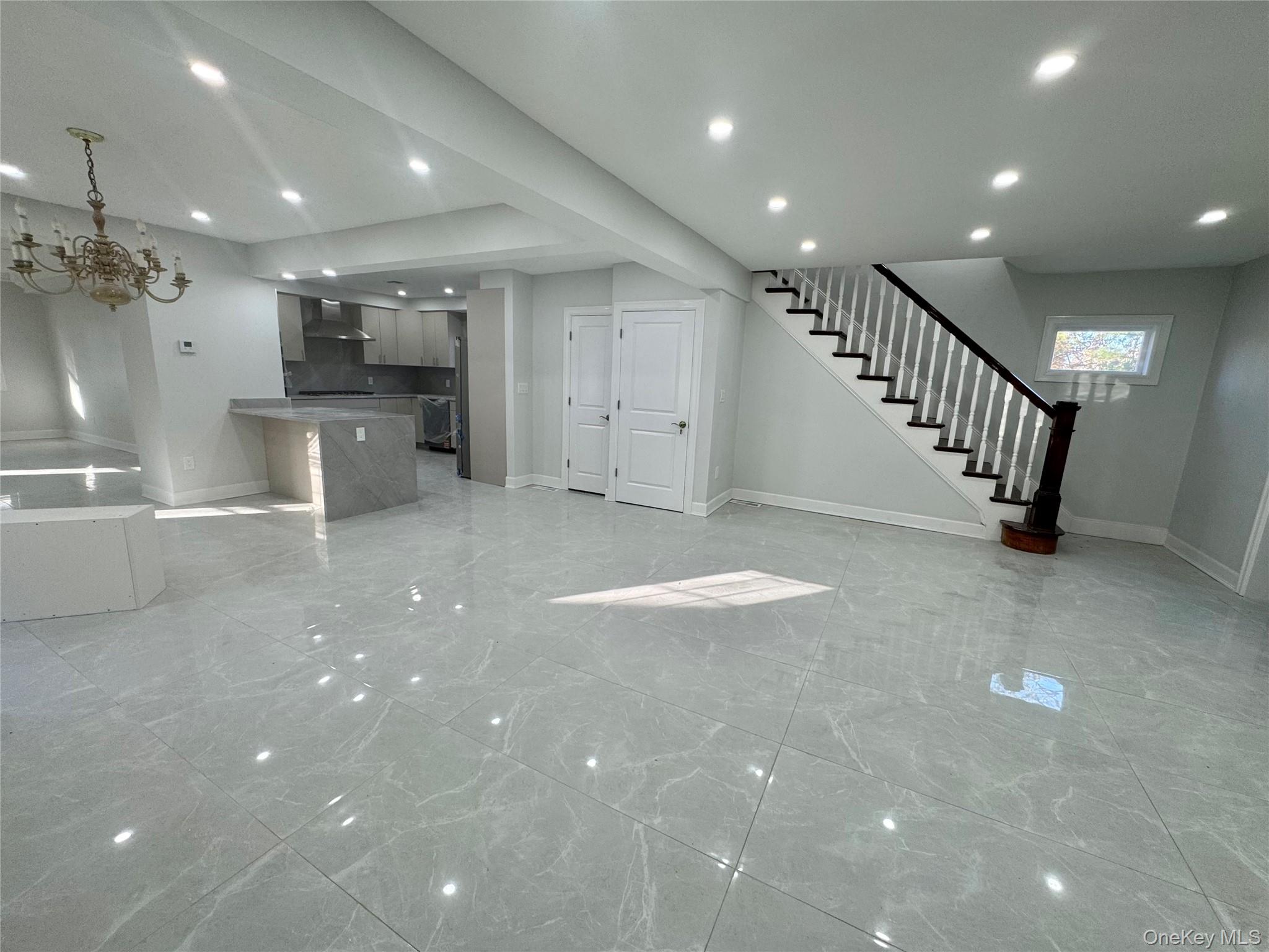32 A Berkshire Road Great Neck, NY 11023 - Photo 2 of 38 Unfurnished living room featuring light marble finish floors, stairway, a chandelier, and recessed lighting