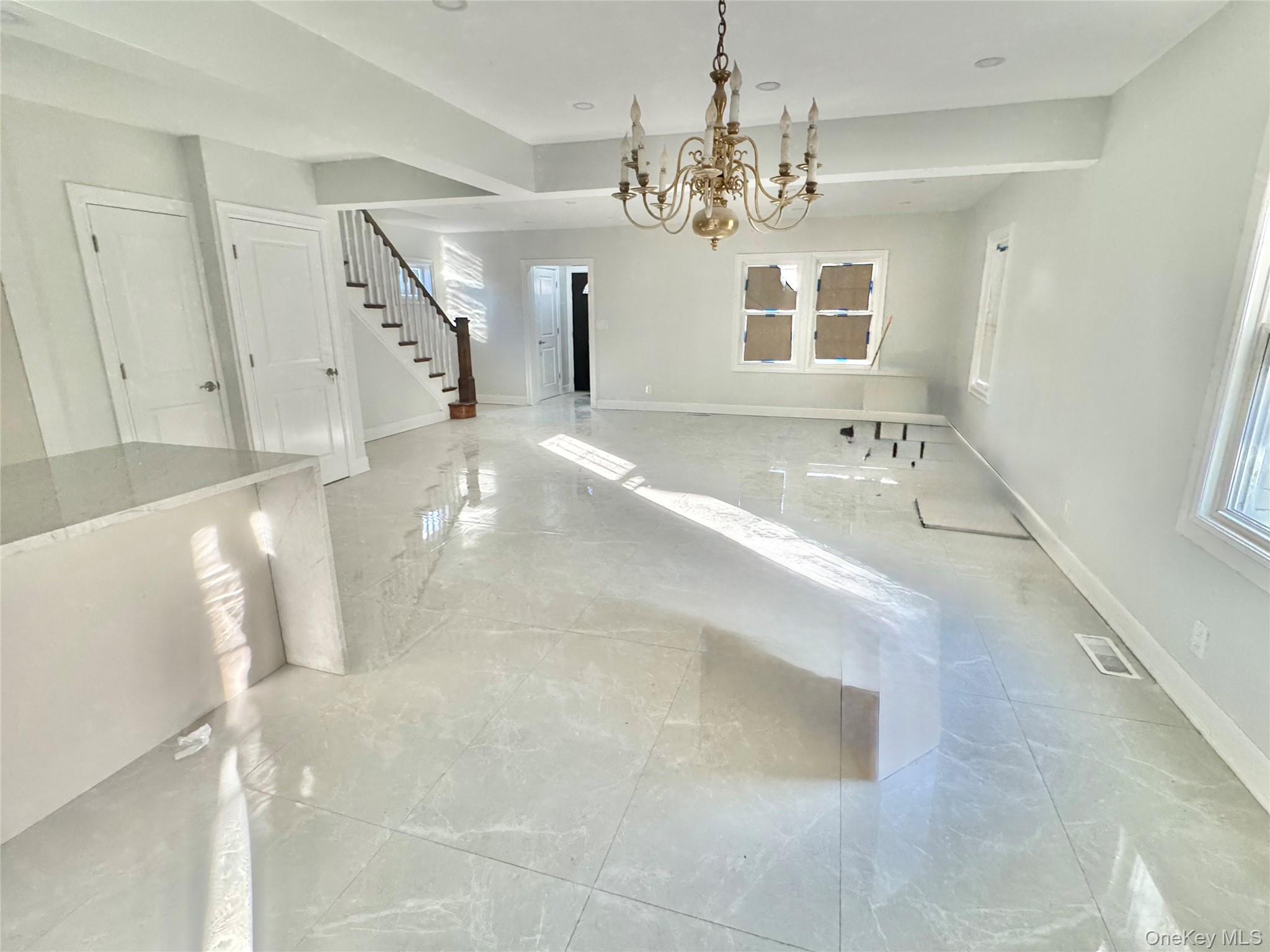 32 A Berkshire Road Great Neck, NY 11023 - Photo 31 of 38 dining area featuring a chandelier, stairway, and marble tiled floors