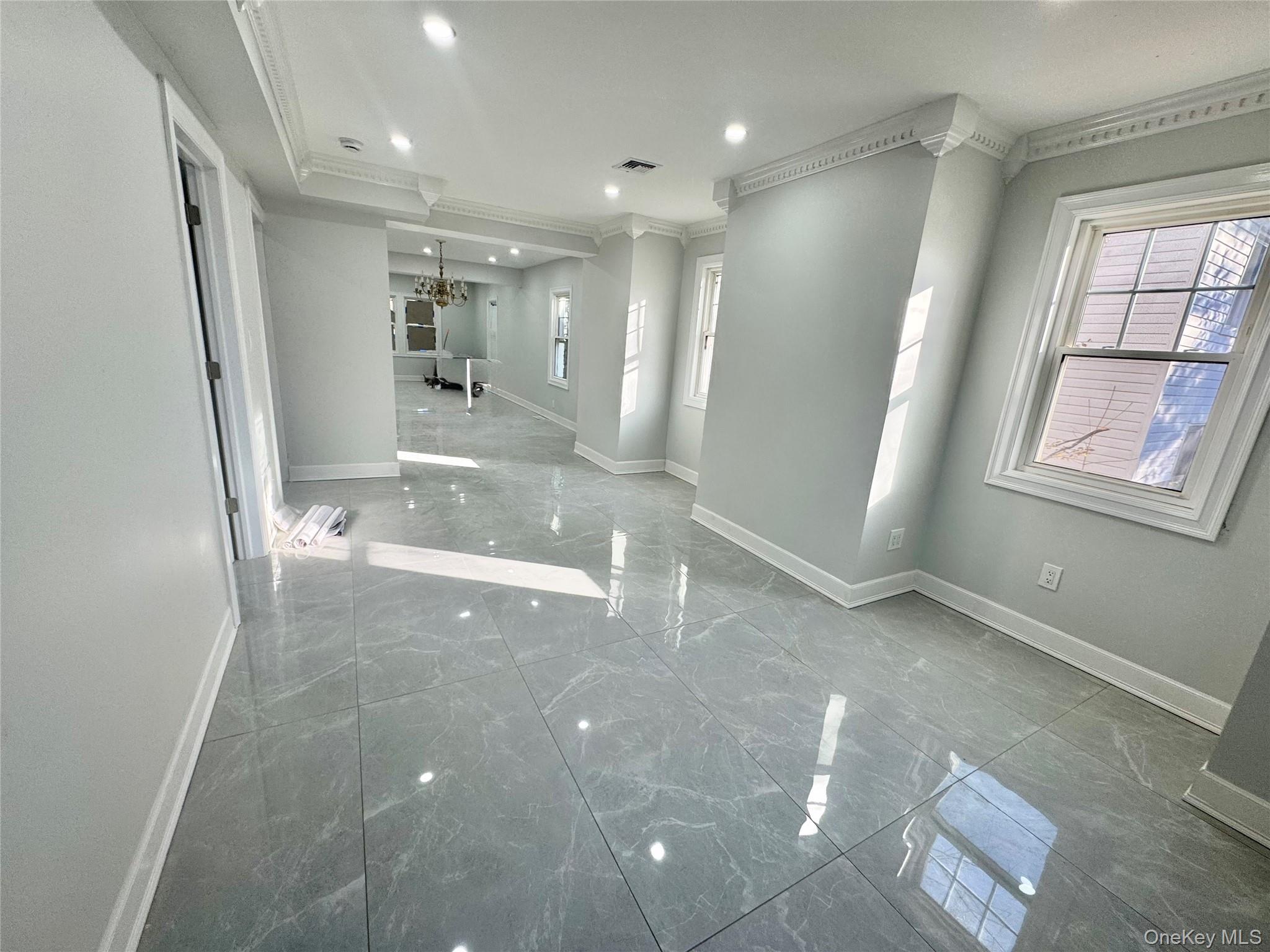 32 A Berkshire Road Great Neck, NY 11023 - Photo 4 of 38 Big room with marble tiled floors, crown molding, a chandelier, and recessed lighting