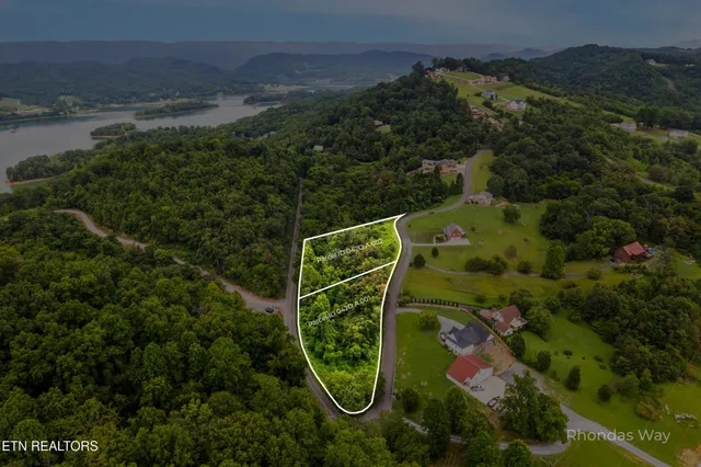 an aerial view of a golf course with a building in the back