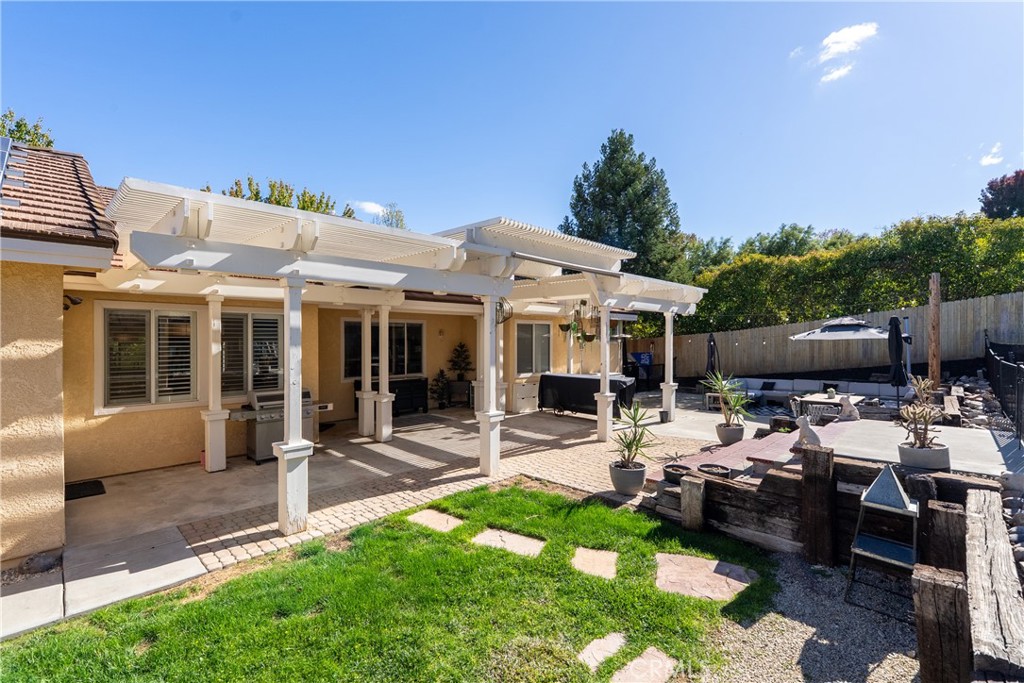 1329 Crown Way Paso Robles, CA 93446 - Photo 38 of 57 a view of a patio with table and chairs potted plants and a large tree