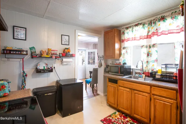 a room with furniture a flat screen tv and a refrigerator