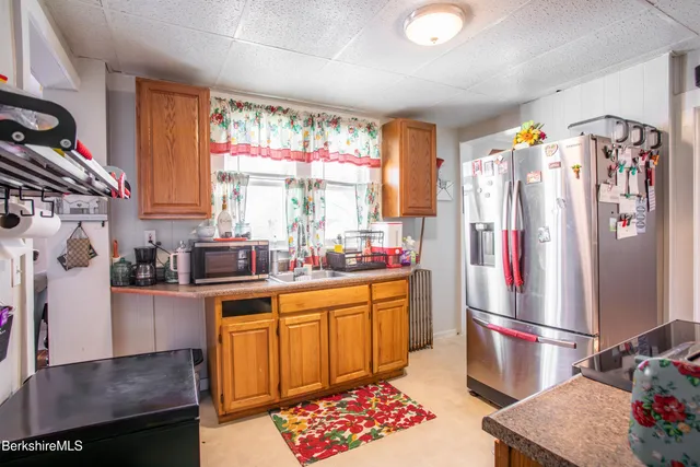 a kitchen with stainless steel appliances granite countertop a refrigerator and a stove top oven