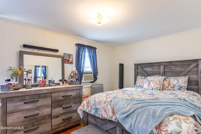 a bedroom with a bed and a large mirror on dresser