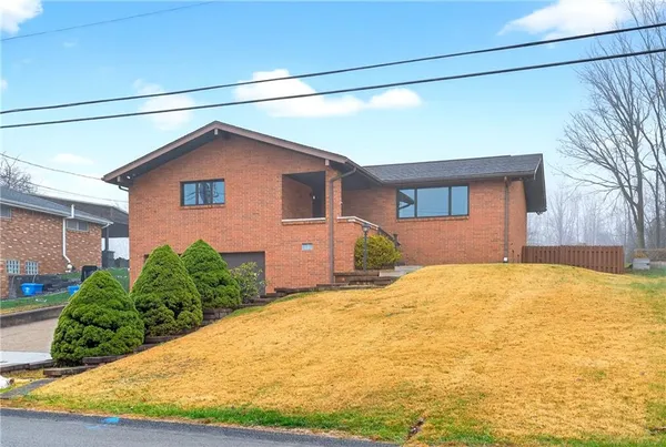 a front view of a house with yard and garage