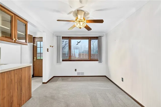 a living room with stainless steel appliances kitchen island granite countertop a refrigerator stove and cabinets
