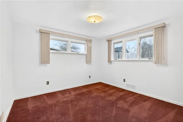 a view of an empty room with a fan and a window
