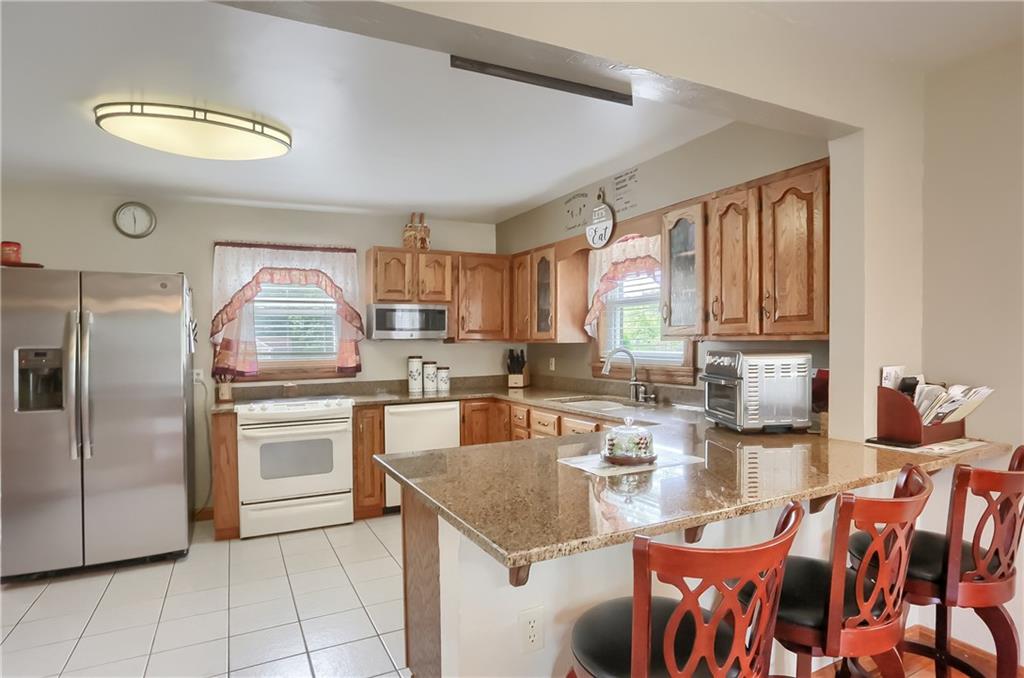 104 Hepler Road Sarver, PA 16055 - Photo 14 of 30 a kitchen with stainless steel appliances granite countertop a stove top oven a sink dishwasher and white cabinets with wooden floor