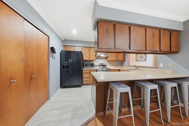 a kitchen with granite countertop a refrigerator a sink and a stove