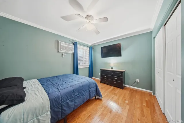 a bedroom with a bed and a flat tv screen on dresser