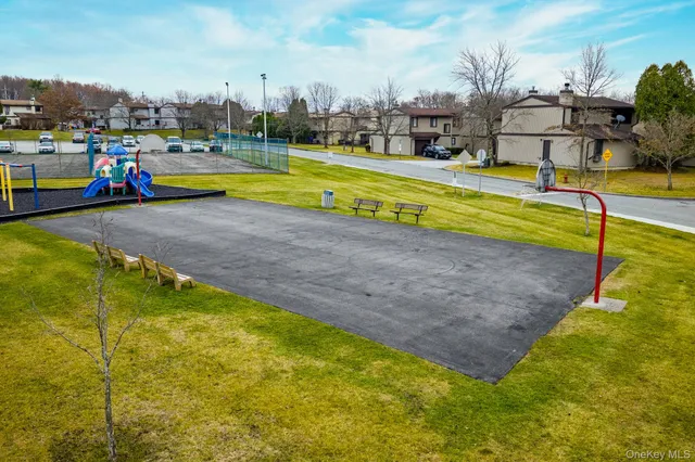 a view of a swimming pool with a lawn chairs and palm trees