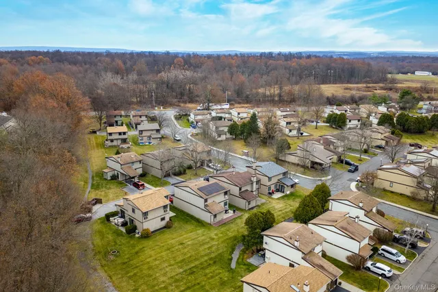 an aerial view of a house with a garden and lake view