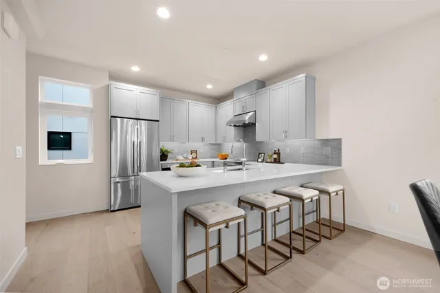 a kitchen with white cabinets and stainless steel appliances