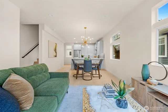 a living room with furniture a dining table and a chandelier