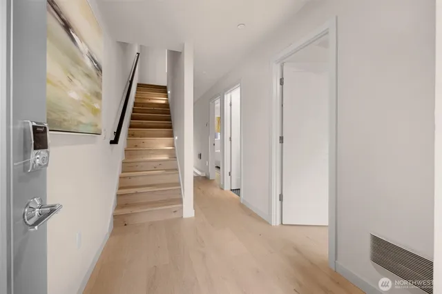 a view of a hallway with wooden floor and entryway
