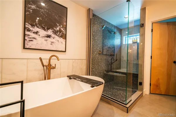 a bathroom with a tub a sink and a large mirror