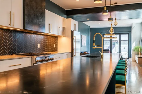 a kitchen with stainless steel appliances granite countertop a sink a stove and refrigerator