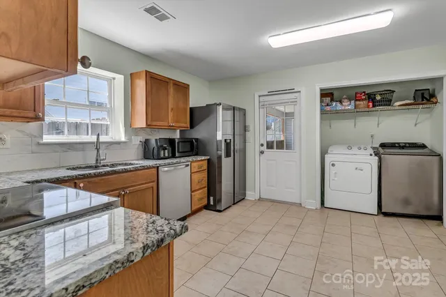 a kitchen with stainless steel appliances granite countertop a sink stove and refrigerator