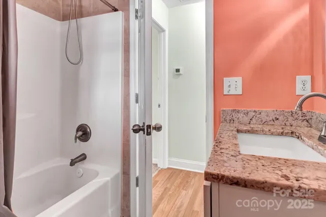 a bathroom with a granite countertop sink a mirror and shower