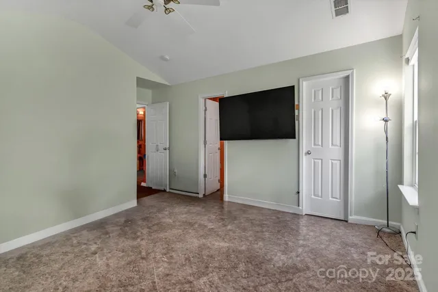an empty room with closet and a flat screen tv