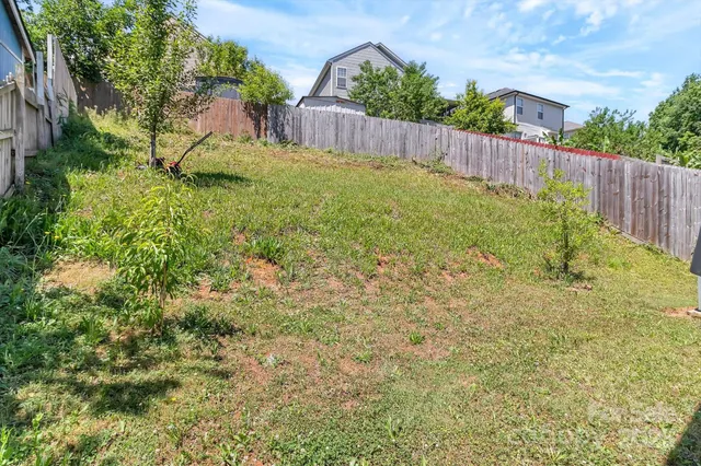 a view of garden with wooden fence
