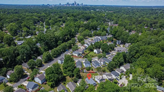 an aerial view of residential house with outdoor space and trees all around