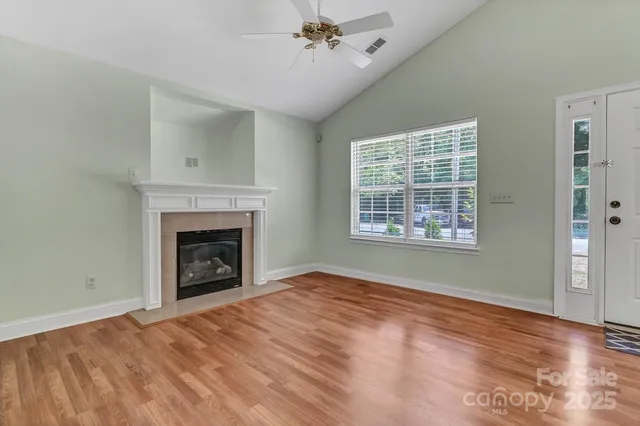 an empty room with windows and fireplace