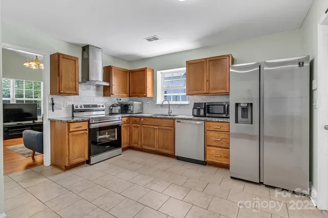 a kitchen with stainless steel appliances granite countertop a refrigerator sink and stove