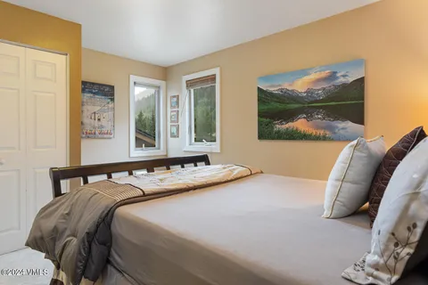 a bedroom with a bed and a painting on the wall