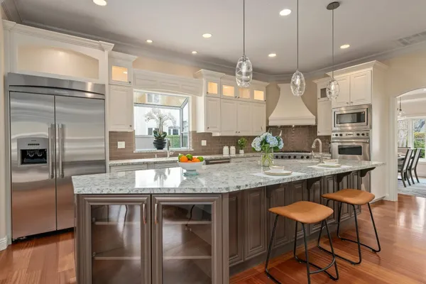 a kitchen with stainless steel appliances granite countertop a stove a sink and a refrigerator