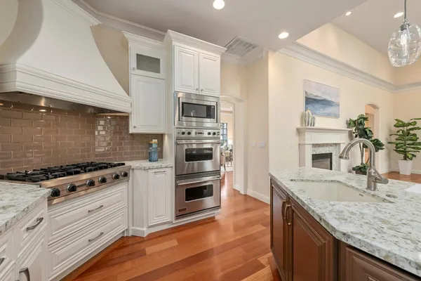 a kitchen with granite countertop a sink stove and refrigerator