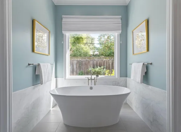 a white bath tub sitting in a bathroom next to a window