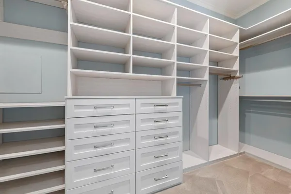 a view of walk in closet with empty racks