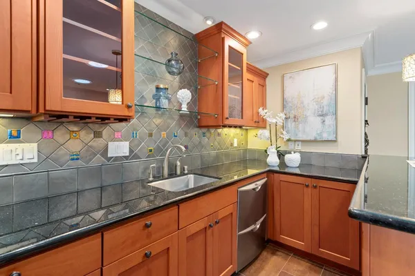 a kitchen with stainless steel appliances granite countertop a sink and a window